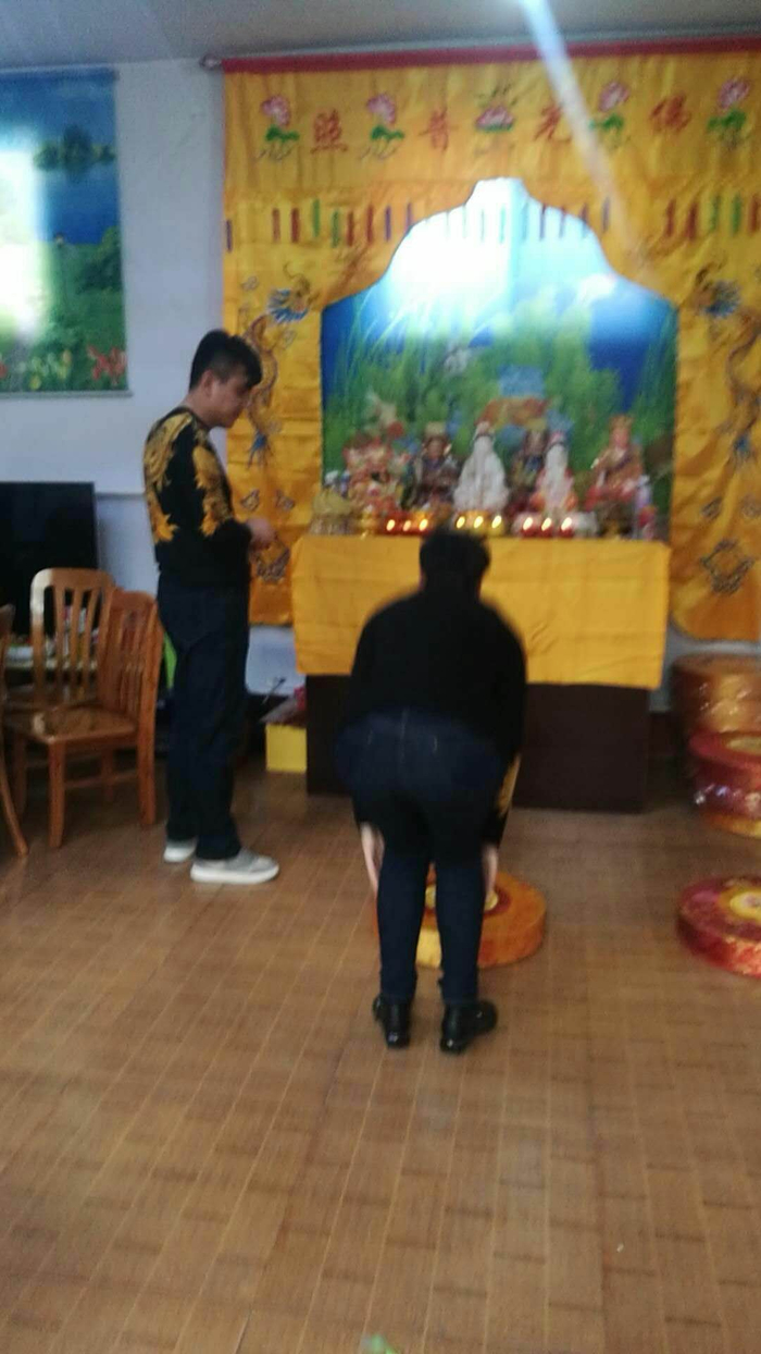 周文登（左）在张家摆置神位，不少人前来跪拜。 受访者供图