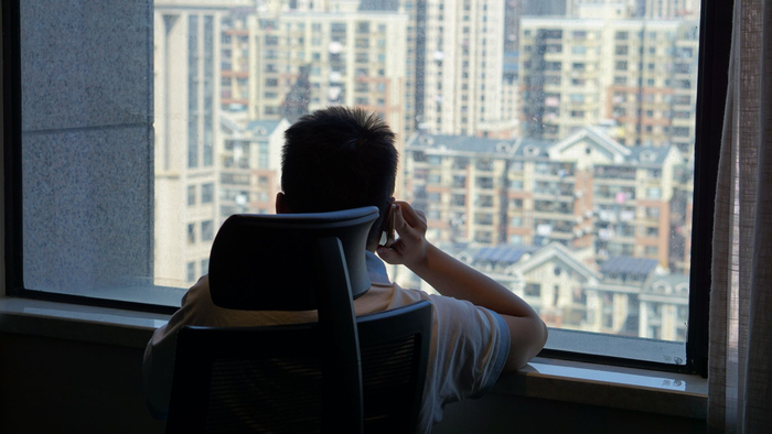 坐在窗前打电话的陆伟。新京报记者卫潇雨&nbsp;摄