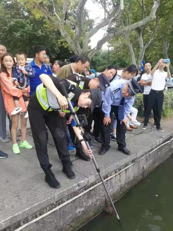 在周翔军的指点下，他的徒弟正在打捞手机。 受访者供图