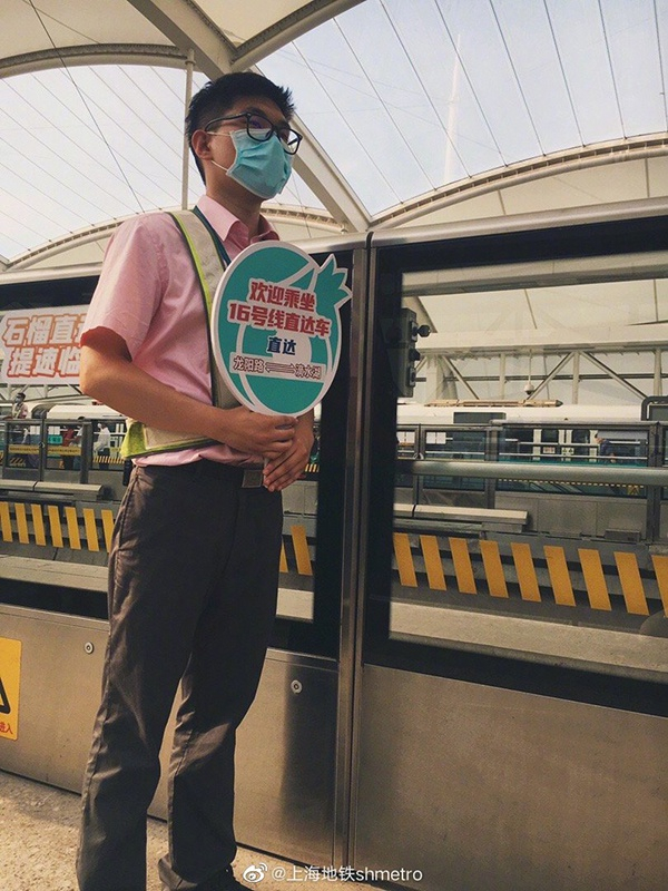 上海地铁16号线龙阳路站台，地铁工作人员手持指示牌，写着“欢迎乘坐16号线直达车”。&nbsp;本文图均为地铁供图