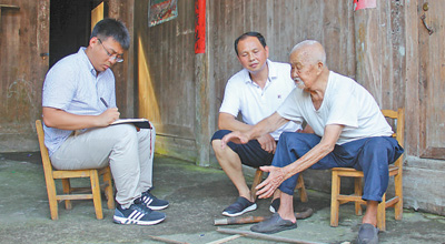 105岁的支义青老人（右一）正在讲述帮红军架设浮桥的过程。本报记者 邝西曦摄