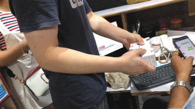 7月16日，印度新德里，一名中国代购选取所需的仿制药后，用手机软件进行价格交流。