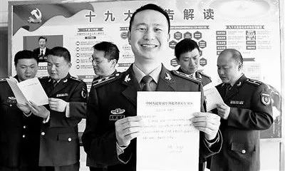 △现役转改文职人员熊成臣（右三）展示转改申请书。