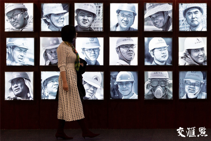 2018年12月14日，在金陵图书馆，一位参观者驻足停留在大桥维修人员的肖像墙前。苏阳 摄 视觉江苏网供图