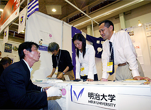 资料图：2007年中国国际教育展上，参观者在日本明治大学的展位咨询。（新华社）