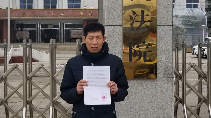 今日（2月2日）中午，张玉玺拿到无罪判决书后，在夏邑县人民法院门口拍照。受访者供图