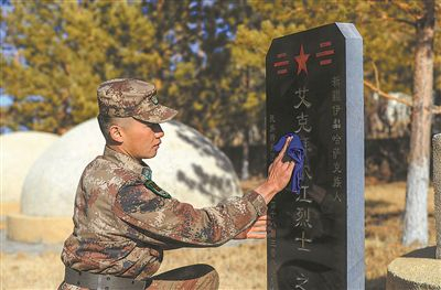活动中，官兵精心擦拭烈士墓碑。