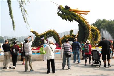 昨日，北海公园，游客在“龙腾盛世”花坛前拍照留念。新京报记者 侯少卿 摄