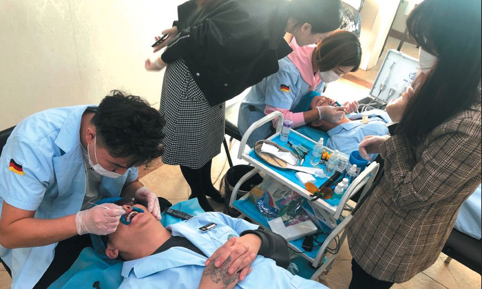 　　▲10月25日，经过一天多的培训后，学员们相互进行贴面操作，作为毕业考试内容。新京报记者 刘经宇 摄