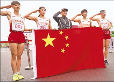 10月23日，中国队成员在女子个人全能越野跑比赛后手持国旗敬礼。当日，第七届世界军人运动会女子个人全能项目比赛在武汉陆军工程大学军械士官学校结束，中国选手卢嫔嫔以5627.2分的总成绩获得冠军，队友管超楠以5567.6分的总成绩获得亚军，王堂林以5506.3分的总成绩获得季军，孙洪燕以5474.1的总成绩获得第四名。新华社记者 王建威摄
