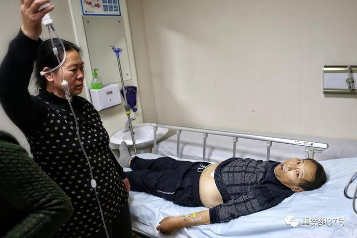 11 月12 日，郑成月在北大第一医院诊室内输液，妻子在旁举着输液袋。&nbsp; 新京报记者 彭子洋 摄