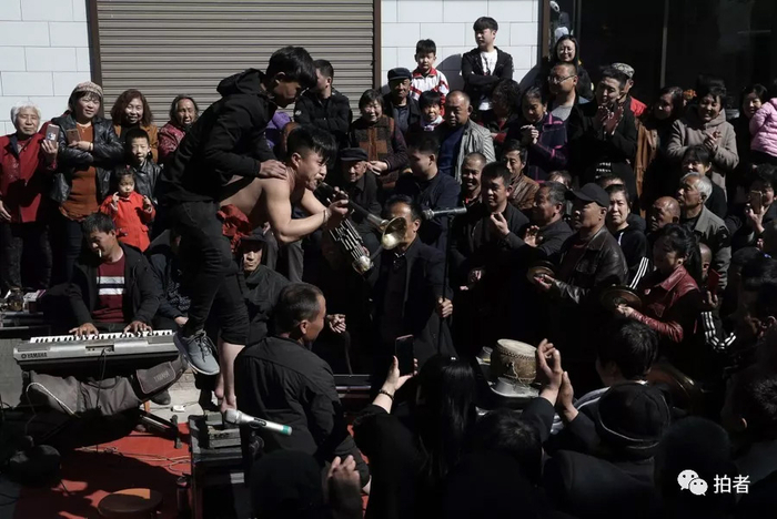 △&nbsp;董鹏光着膀子，在背着一名男子的情况下还赤脚站在菜刀上吹着唢呐，引得参加葬礼的观众们赞叹不已。