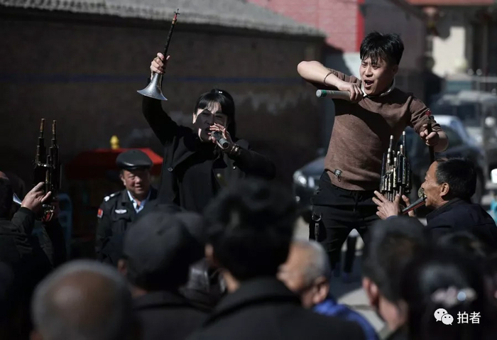  △ 送灵人董鹏站在高处，手拿麦克风竭力喊着节奏，带领“敲打”将气氛推向高潮。