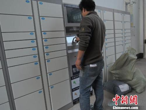 资料图：快递员使用智能快递柜投送包裹。韩章云 摄