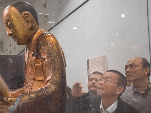 杨永前（右一）在观察肉身佛像