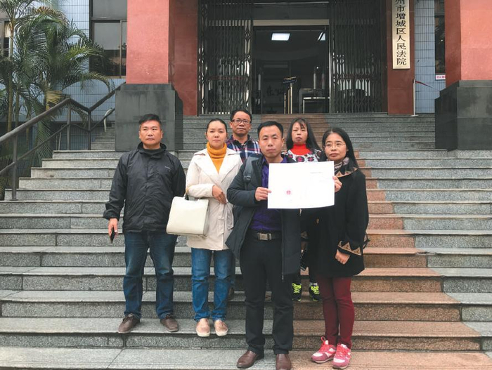 昨日，该案宣判后，几名被拐幼儿的家长拿着判决书在法院门口合影。 &nbsp;&nbsp;&nbsp;&nbsp;受访者供图