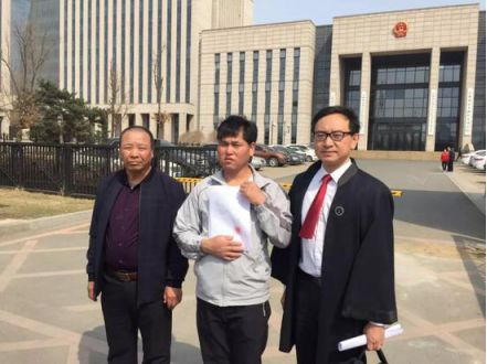 　　宣判后，刘忠林（中）在张宇鹏律师（右）与姐夫的陪同下走出法庭，向媒体出示无罪判决书。（来源：新京报）