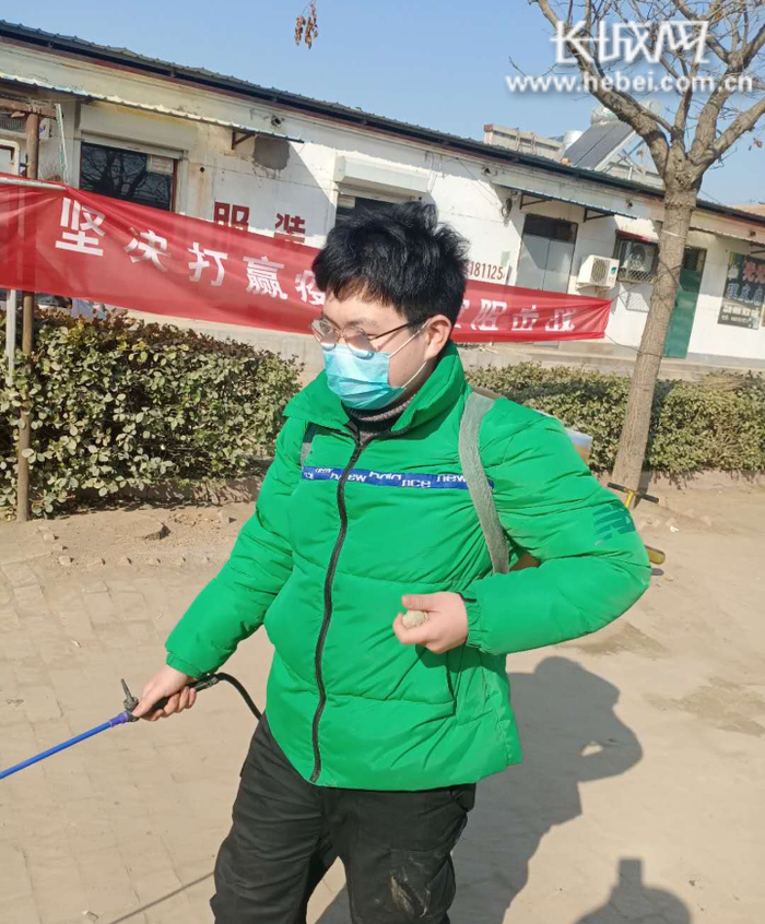 李新宇对村内的大街小巷进行消毒。崔佳栋 供图