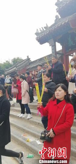  3月8日，中国农历二月二，是中国民间“龙抬头”之日。当日，“己亥年公祭中华人文始祖太昊伏羲氏大典”在河南淮阳举行。图为前往太昊陵的香客手拿免费的“环保香”。　齐永 摄
