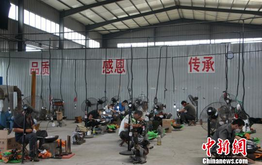 　　图为章丘铁锅手工冷锻厂，铁匠们每人守一台风扇，戴耳塞、口罩等防护工具，手中握锤，正在打造铁锅。　赵晓　摄