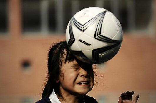  练习头球的孩子。