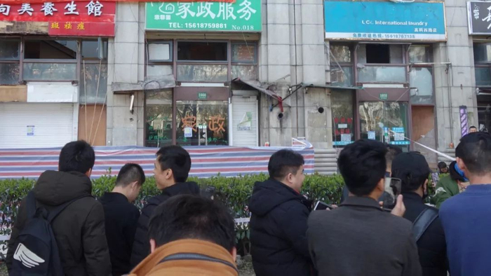 被警戒线隔开的人群。