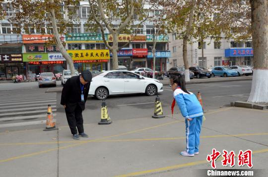 　记者当日在现场看到，在张善德鞠躬问好后，小学生们也会自发停下来，向老人鞠躬问好。　郝学娟 摄