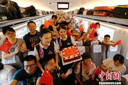 长编组“复兴号”动车组，列车员与旅客庆祝这一时刻。　殷立勤 摄