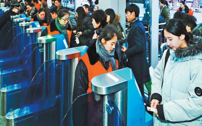 2月1日，旅客正在北京西站通过自助验票设备“刷脸”进站。该站今年增加了18台人脸识别设备，方便旅客快速进站。本报记者 贺 勇摄