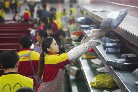 嘉民重庆空港物流中心，一快递公司的工作人员正在分拣快递。 （资料图片）