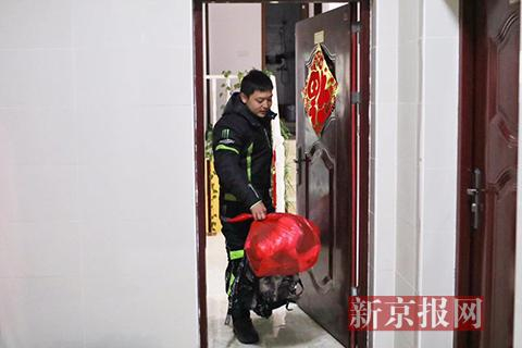 邓军拎着行李走出家门。