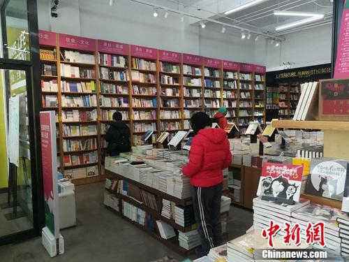 北京言几又书店（中关村店）内，读者正在翻看摆放的书籍。上官云 摄