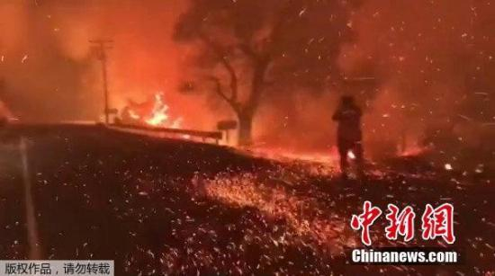 山火借助风力迅速蔓延，图为加州一公路上火星四溅。（视频截图）