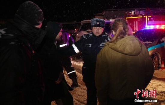　　当地时间2月11日，一名警察在阻挡媒体记者通过警方为坠机地点设置的警戒线。 中新社记者 王修君 摄