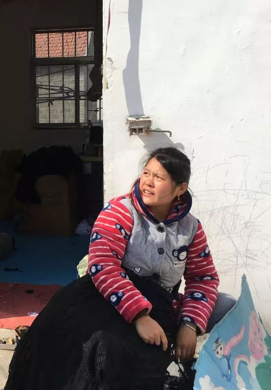 加工厂门口，一个女工抱着新款黑色内衣。新京报记者陶若谷 摄