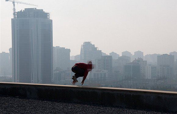同行的跑酷伙伴用手机拍摄冷俊跃出平台的瞬间