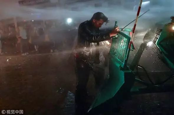 当地时间2017年7月8日，德国汉堡，G20峰会后一名男子站在警方清障车上。（图片来源：视觉中国）