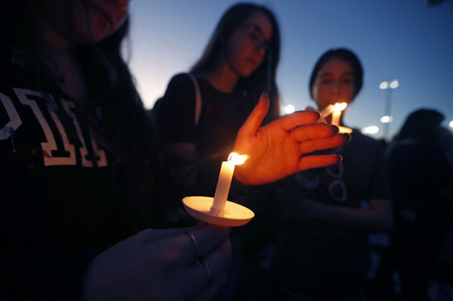 2月15日，在美国佛罗里达州南部帕克兰市，人们参加悼念枪击案遇难者的烛光守夜活动。（新华社/美联）