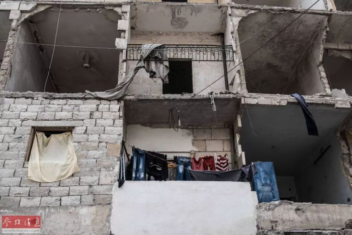 ▲阿勒颇解放已经一年，尽管很难相信这些断壁残垣里有人居住，但从挂着的五颜六色的衣服上不难看出，曾经流离失所的人们正陆续返回家园。