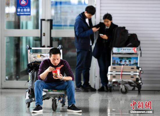 资料图：旅客等待登机。 中新社记者 刘新 摄