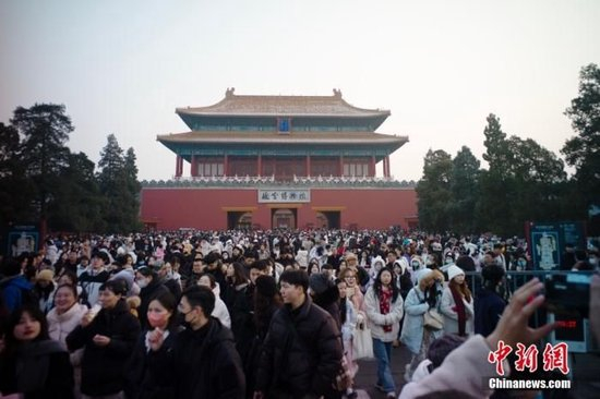 资料图：元旦假期首日，游客们走出故宫博物院。中新社记者 盛佳鹏 摄