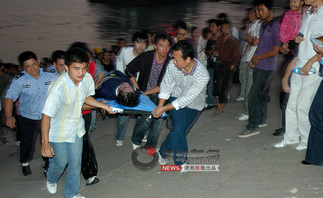 师生与警察将第三名遇难学生抬上救护车