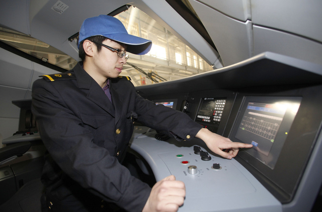 技术人员在司机室通过显示屏数据检查动车组状态