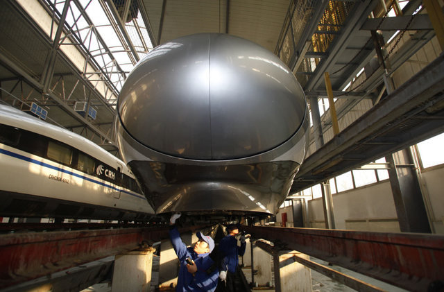 地勤机械师在对动车车下设备进行检修作业