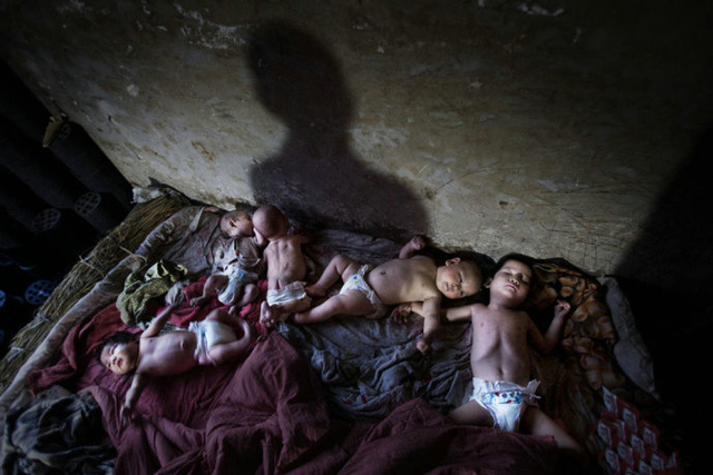 五个弃婴躺在草垫子和脏被褥铺就的床上