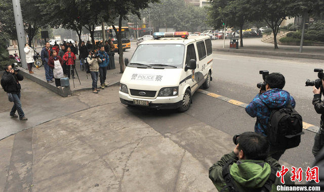警车拉着周克华的女友张贵英进入法院