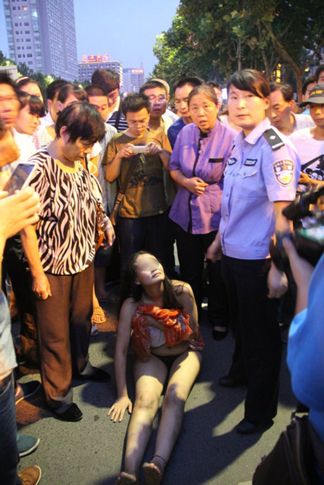 郑州女子街头裸奔与交警对峙被抬走