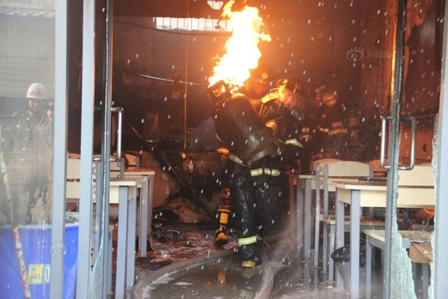 消防员抱起火煤气罐冲出火场