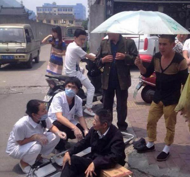 老人街边摔倒 修车工不顾劝阻出手相救