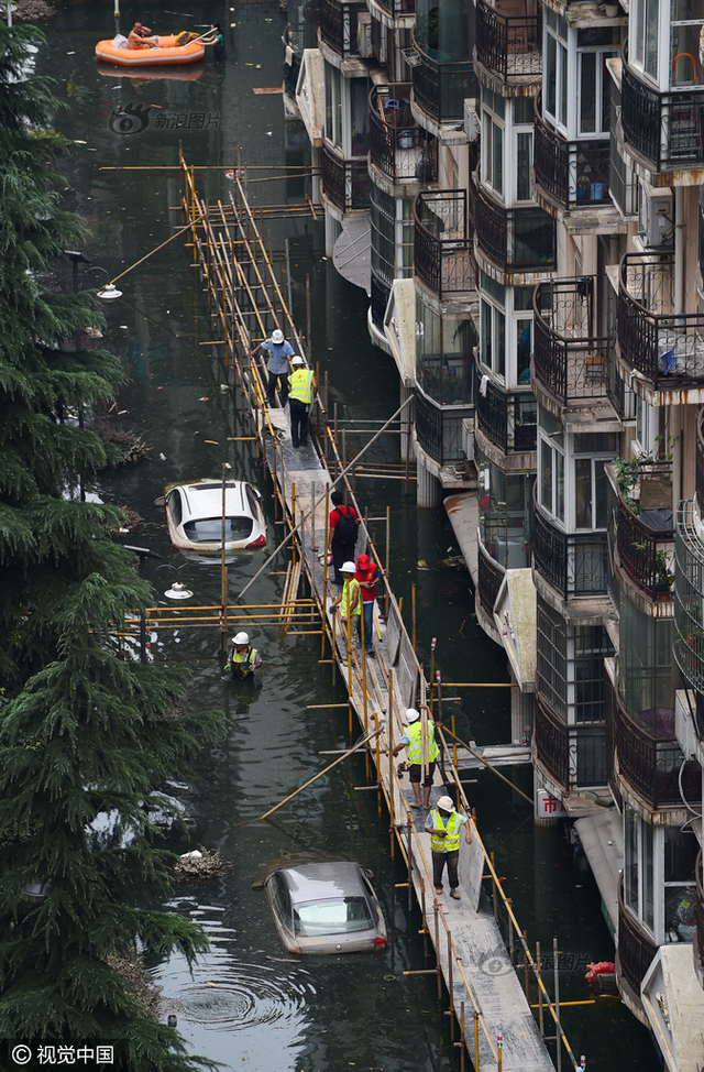 工人在积水小区搭栈桥